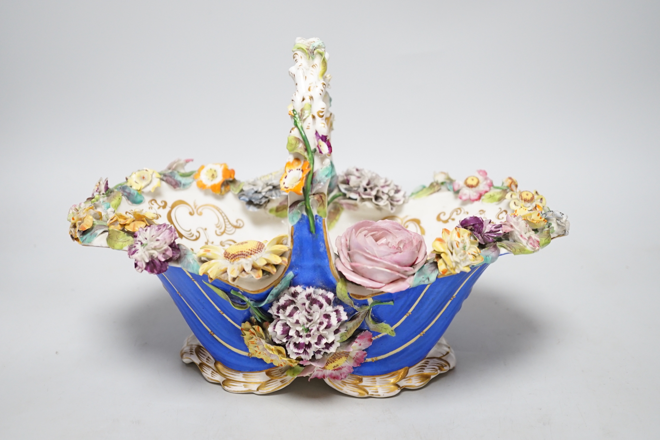 A Rockingham type floral encrusted china basket, 32cm